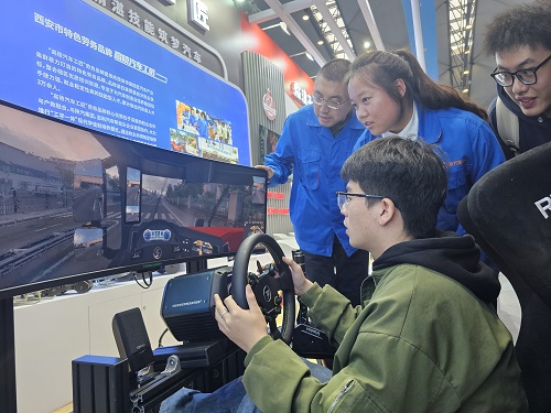 “高陵汽车工匠”劳务品牌展区工作人员正在指导观展人员操作重卡驾驶模拟器.jpg